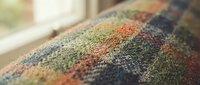 Colorful woven textile fabric with multicolored threads creating vibrant pattern, close-up detail of home decor upholstery material for interior design projects.