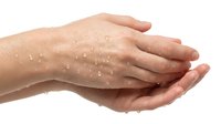 Cupped hands with water droplets on skin showing hydration and moisture care isolated on white background for skincare and wellness design concepts.