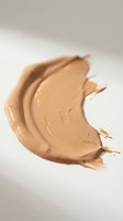 Creamy foundation makeup smear with smooth texture on neutral background for cosmetic and beauty product advertising campaigns.