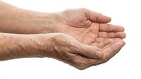 Elderly hands cupped together in receiving gesture on white background, showing aged skin texture and wrinkles, isolated for design use.