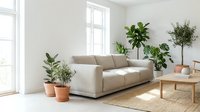 Spacious living room with beige sofa, potted plants, wooden furniture, and natural light from large window. Minimalist interior design for home decor and lifestyle content.