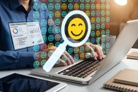 Business professional using laptop with digital smiley face emoji feedback system for customer satisfaction survey and online review management.