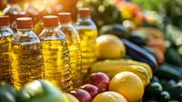Fresh cooking oil bottles with colorful organic vegetables and fruits on kitchen counter for healthy meal preparation and culinary cooking needs.