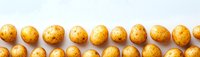 Fresh raw yellow potatoes arranged in neat rows on white background, organic farm vegetables, top view panoramic banner composition for food design.