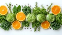 Fresh oranges, cabbage heads, kale leaves and aromatic herbs arranged in decorative pattern on white background. Healthy eating concept for food blogs.