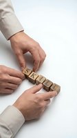 Close-up of two male hands in business attire arranging wooden blocks spelling skill, representing professional development, training, and career growth concepts.