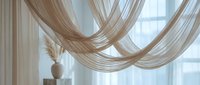Sheer beige curtains draped elegantly across a window, creating flowing waves of translucent fabric with soft natural light filtering through, suitable for interior design and home decor projects.