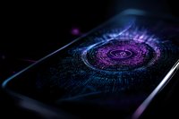 Glowing purple digital interface on smartphone screen with futuristic circular pattern and binary code elements in dark atmospheric setting.