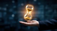Glowing hourglass floating above businessman hand against dark bokeh background symbolizing time management, deadline pressure and business efficiency concepts.