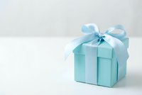 Light blue gift box with satin ribbon bow on white background, perfect for holiday, birthday, and baby shower celebration concepts.