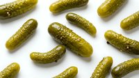 Fresh green pickles arranged on white background, isolated produce for food packaging, culinary, and restaurant design use.