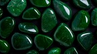 Polished dark green aventurine stones arranged in pattern showing smooth surface and natural mineral variations. Crystal healing and meditation background.