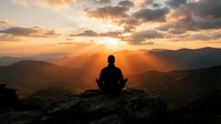 Person meditating on mountain peak during golden sunset with dramatic clouds and layered hills creating peaceful spiritual atmosphere for wellness content.