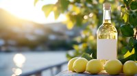 Fresh lemons and bottle of white wine on wooden surface against blurred water background with sunlight and green leaves, creating summer mood.