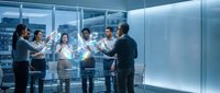 Business team collaborating with holographic data visualization in modern glass conference room with futuristic technology interface.