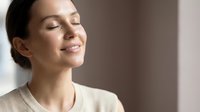 Peaceful young woman with closed eyes enjoying moment of tranquility and mindfulness in soft natural light for wellness and meditation concepts.