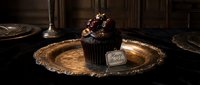 Decadent dark chocolate birthday cupcake on a vintage golden tray, dramatic moody lighting, elegant gothic celebration concept.