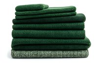 Stack of folded green knitted blankets and throws in various textures, isolated on white background, ready for home decor and retail design use.