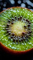 Macro shot of fresh kiwi fruit slice showing detailed texture, seeds and water droplets against dark background, vibrant green color and juicy flesh.