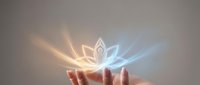 Hands holding glowing lotus flower with radiant light rays, symbolizing spirituality, healing, and wellness for meditation and mindfulness applications.