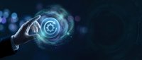 Hand holding glowing target symbol with digital particles and light effects on dark background for business strategy and marketing concepts.