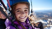 Young girl enjoying winter ski lift ride with safety helmet and purple jacket smiling at snowy mountain resort during family vacation adventure.