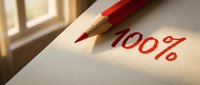 Red pencil writing 100% on white paper with warm sunlight creating dramatic shadows for business success and achievement concepts.