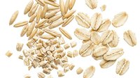 Organic oat flakes and grains scattered on white background, healthy breakfast cereal ingredients isolated for cooking and nutrition design projects.