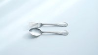 Elegant silver fork and spoon set with ornate handles on clean white background, isolated cutlery for kitchen dining and restaurant design projects.