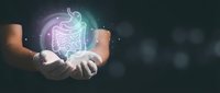 Hands presenting glowing digestive system hologram with stomach and intestines for medical healthcare education and gastroenterology concept.