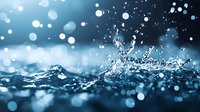 Dramatic water splash with bokeh light effects on dark blue background creates mesmerizing macro photography composition showing liquid dynamics and motion blur.