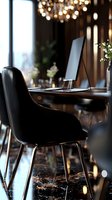 Modern workspace in luxury restaurant interior with laptop on wooden table, black designer chair and ambient lighting from hanging lamps above.