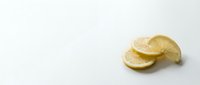 Fresh lemon slices arranged on a white background, showcasing vibrant yellow citrus fruit with natural texture and juicy detail.