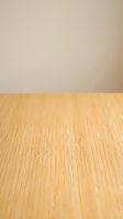 Empty wooden table surface with beige wall background for product display and presentation purposes in minimalist interior design setting.
