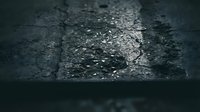 Cracked asphalt road surface with weathered texture and damaged pavement showing wear from traffic and weather conditions creating urban decay atmosphere.