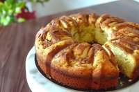 Golden bundt cake with swirled pattern on white plate, homemade dessert for celebrations and gatherings. Fresh baked treat for coffee time and special occasions.