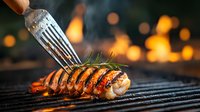 Grilled shrimp on barbecue with fork, flames and bokeh lights in background. Juicy seafood with rosemary herb and grill marks cooking on hot griddle.