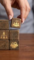 Hand placing wooden block with teamwork icons on stack representing business strategy and leadership development concepts for corporate training.