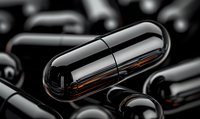 Black medical capsules with amber liquid inside on dark background, macro pharmaceutical photography showing translucent medicine pills in dramatic lighting.