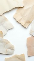 Torn aged paper pieces scattered on white background creating vintage texture frame with copy space for creative design projects.