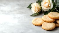 Homemade butter cookies with cream roses on light marble background, selective focus. Fresh baked traditional shortbread biscuits for afternoon tea time.