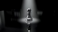 Chess pawn piece standing alone in dramatic spotlight on reflective surface with dark background for strategic business concepts.