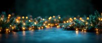 Glowing Christmas lights and pine branches create magical holiday atmosphere on dark blue background with bokeh effect and copy space.