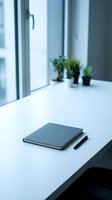 Minimalist office workspace with closed notebook and pen on white desk near window with green plants in modern business interior for productivity and planning.