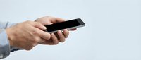 Professional businessman hands holding modern black smartphone for mobile communication and digital technology applications in office environment.