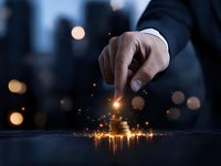 Businessman's hand touching glowing magical light effect on dark surface with bokeh city background, creating mystical business transformation concept.