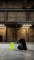 Fitness equipment arranged on concrete floor in industrial warehouse setting with exposed brick walls and overhead lighting, suitable for gym, workout, and training concepts.