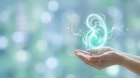 Female hands cupping glowing kidney organ with sparkles on soft blue green bokeh background for medical healthcare and organ donation awareness campaigns.