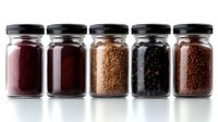 Assorted spices and legumes in glass jars with black lids arranged in row on white background, showcasing vibrant colors and textures for cooking.