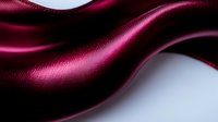 Luxurious burgundy silk fabric with elegant waves and folds creating smooth curves and dramatic shadows against dark background. Soft textile with satin sheen effect.
